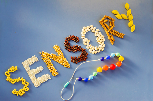 Sensory word written of rice, popcorn, beans, pasta. Sensory play for child at home. Activities Montessori, games for sensory processing disorder, child development and occupational therapy